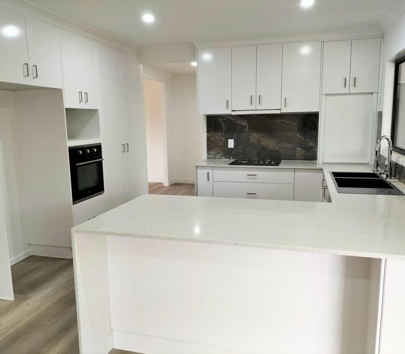 White kitchen with island and dramatic stone splashback