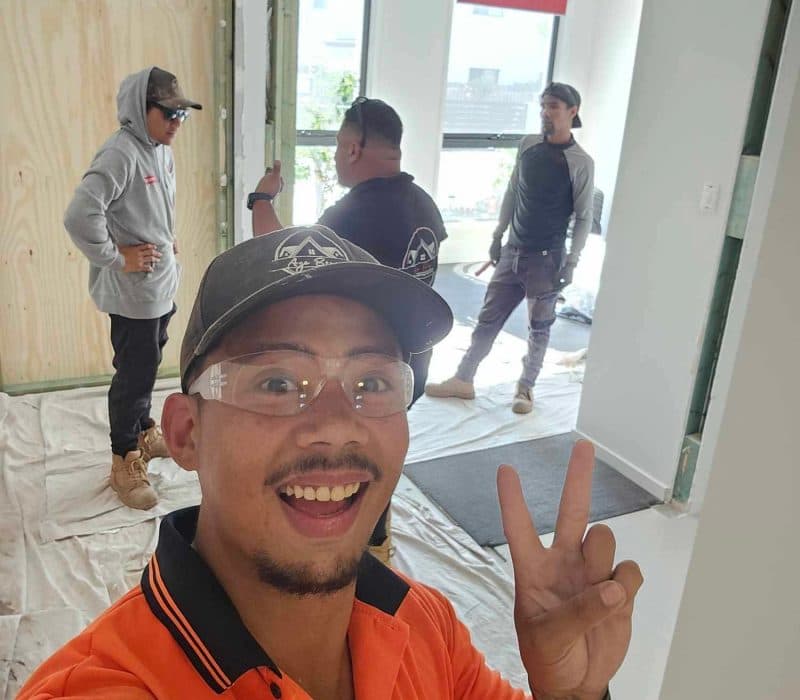 BuildBros tradie on site, crew working in the background