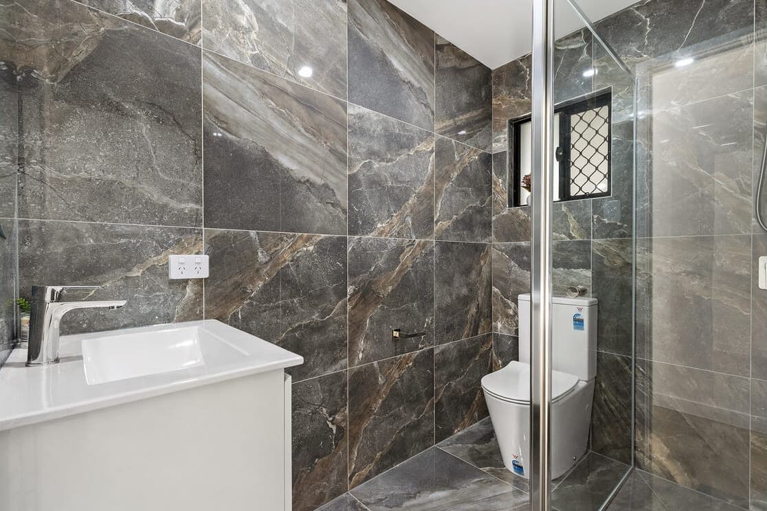 Dark marble bathroom with white vanity