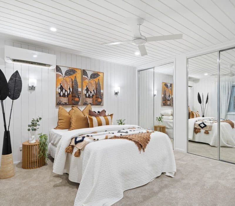 Renovated bedroom with art panels and white panelled walls